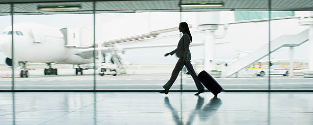 femme d'affaires avec des bagages à l'aéroport - travel photos et images de collection
