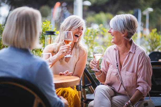 femmes âgées heureux boire du vin et de rire ensemble au restaurant - food photos et images de collection