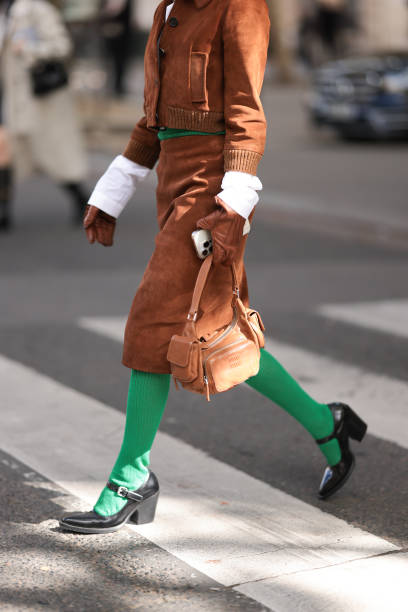 Fer Millán Delaroière is seen wearing a matching two-piece in brown suede from Miu Miu, consisting of a cropped jacket with ribbed trims, a black...