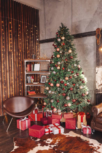 festive room with decorated christmas tree surrounded by gifts - home decoration stock pictures, royalty-free photos & images