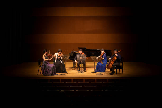 five musicians playing violin, viola, and cello at classical music concert - concert stock pictures, royalty-free photos & images