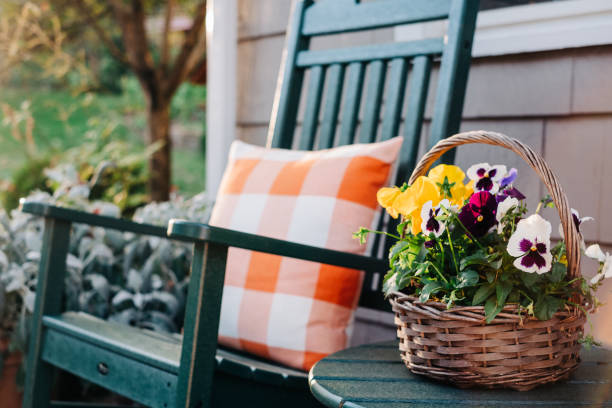 flower basket next to a green rocking chair - garden decoration stock pictures, royalty-free photos & images