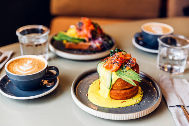 fluffy pancakes with salmon and avocado served for breakfast at the restaurant - food stock pictures, royalty-free photos & images