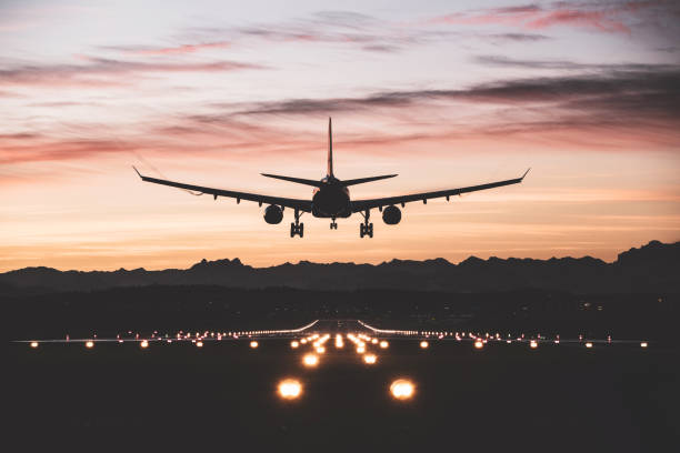 flugzeug landet bei sonnenaufgang - travel stock-fotos und bilder