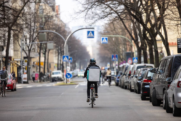food courier person with thermal backpack on city street - junk food stock pictures, royalty-free photos & images