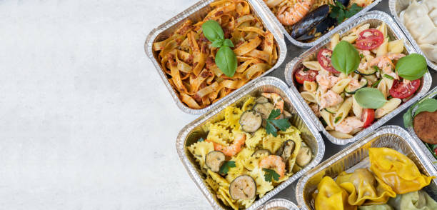 food delivery. different aluminium lunch box with healthy natural chinese food dumplings, noodles with chicken, rice with chicken, pasta with salmon, falafel. airlines food. airline meals and snacks. takeaway food. - junk fo