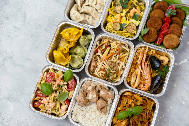 food delivery. сhinese takeaway food, italian food delivery. different aluminium lunch box with dumplings, noodles with chicken, rice with chicken, pasta with salmon, falafel - junk food stock pictures, royalty-free photos &