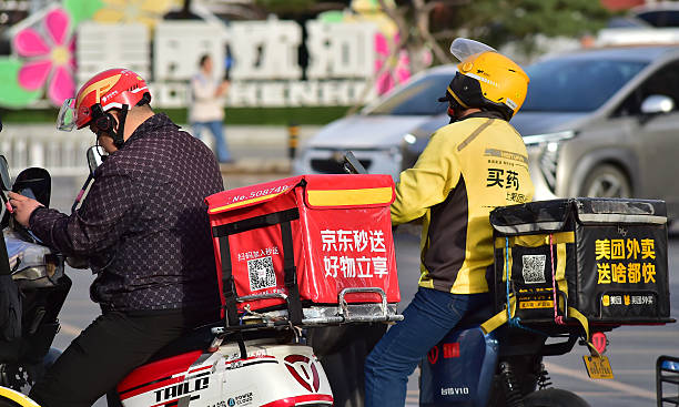 Food delivery riders of JD Takeaway , the food delivery service under China's e-commerce giant JD.com, and Meituan wait for the green light on the...