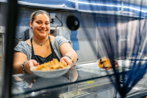 food service worker holding a plate of salad with gyros at a diner - junk food stock pictures, royalty-free photos & images