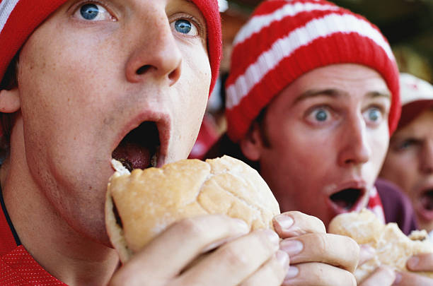 football supporters at match, holding hambugers, gasping - food stock pictures, royalty-free photos & images