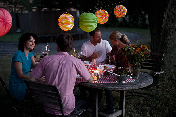 four people at a dinner party - garden decoration stock pictures, royalty-free photos & images