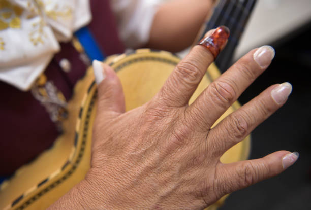 Frank Rodriguez protects his fingernails with fake nails to play the vihuela, a five string guitar. Rodriguez is a member of Mariachi Sol De Mi...