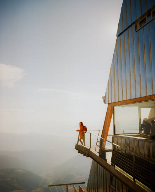 frau steht auf dem balkon einer modernen berghütte in den dolomiten - travel stock-fotos und bilder