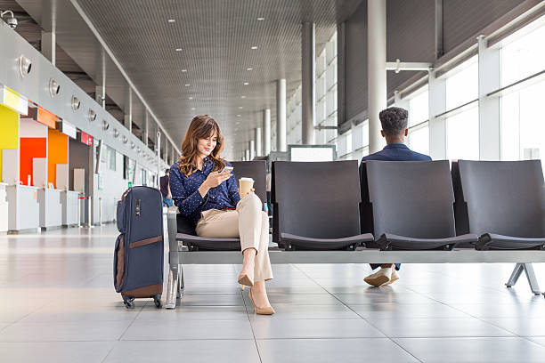 frau wartet auf flug in der flughafen-lounge - travel stock-fotos und bilder