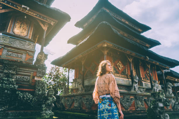 frau zu fuß im balinesischen tempel - travel stock-fotos und bilder