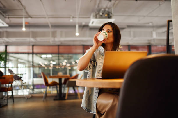 freelance woman working at laptop in coworking - junk food stock pictures, royalty-free photos & images