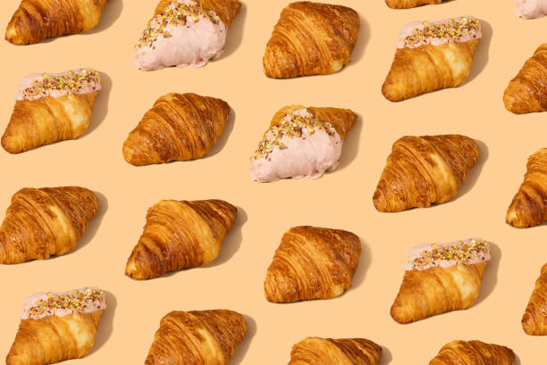fresh croissant against a pastel peach background - food stock pictures, royalty-free photos & images