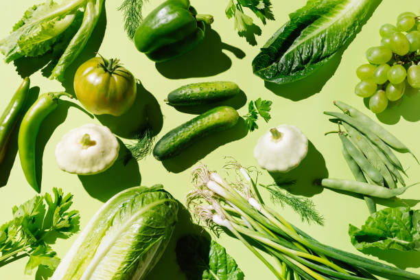 fresh green organic vegetables and fruits on green background. healthy food, diet and detox concept. flat lay, top view - food stock pictures, royalty-free photos & images