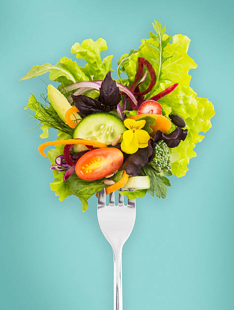 fresh salad on a fork. - food stockfoto's en -beelden