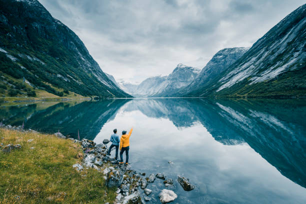 friends admiring the view on the banks of a norwegian fjord, norway - travel stock pictures, royalty-free photos & images