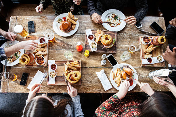 friends at a pub eating, birds view - food stockfoto's en -beelden