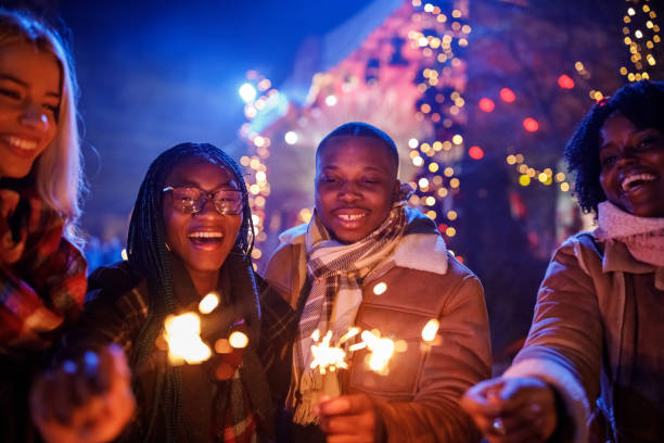 friends at the new year's eve concert dancing and waving sparklers - concert stock pictures, royalty-free photos & images