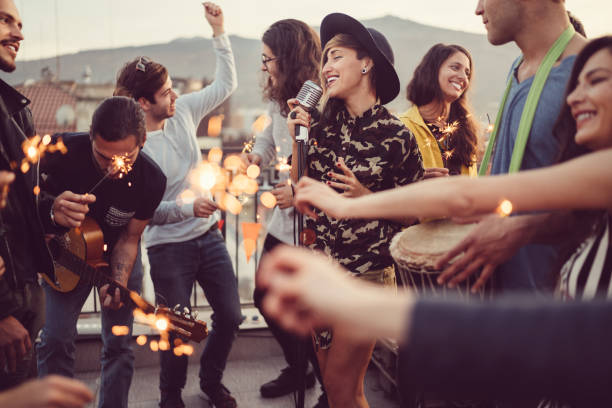 friends celebrating new year on rooftop party - concert stock pictures, royalty-free photos & images