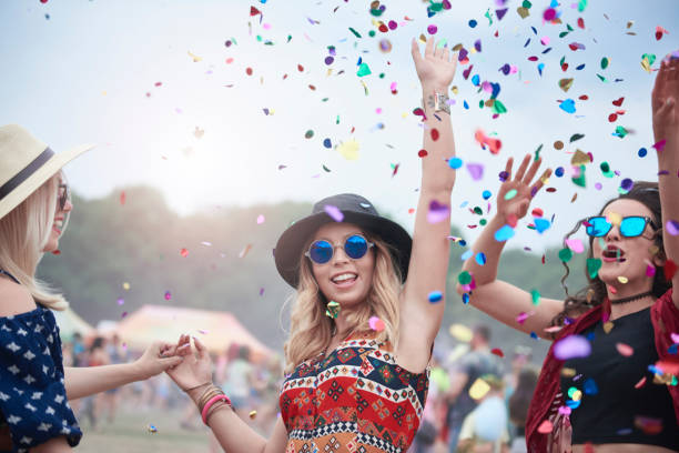 friends dancing among confetti at the music festival - concert stock pictures, royalty-free photos & images