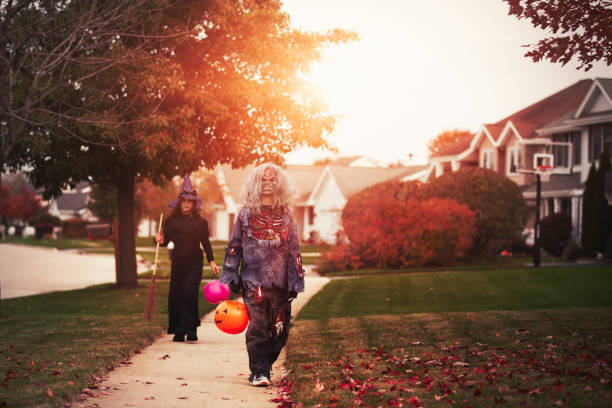 friends dressed as witch and zombie, trick or treating in neighbourhood - garden decoration stock pictures, royalty-free photos & images
