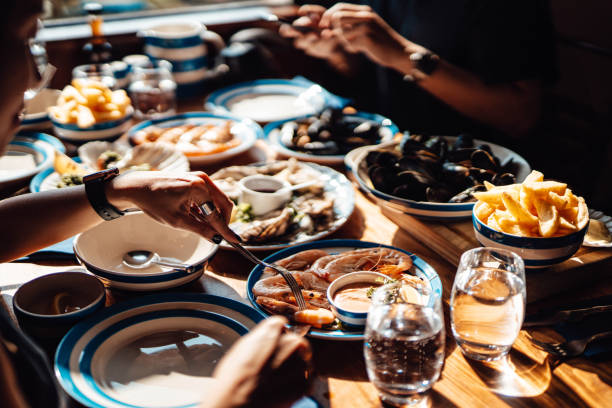 friends eating fresh seafood in restaurant - food stock pictures, royalty-free photos & images