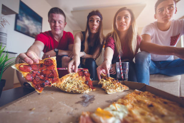 friends eating pizza - junk food stock pictures, royalty-free photos & images