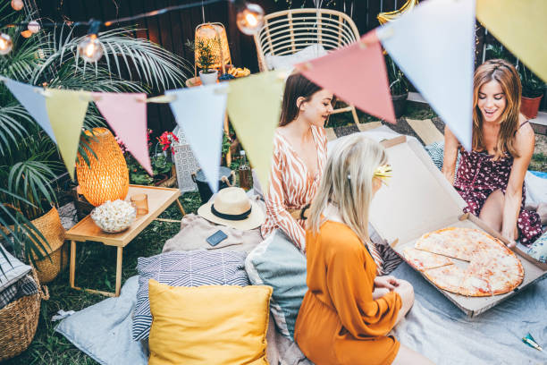 friends eating pizza and having a fun at the garden party. - junk food stock pictures, royalty-free photos & images