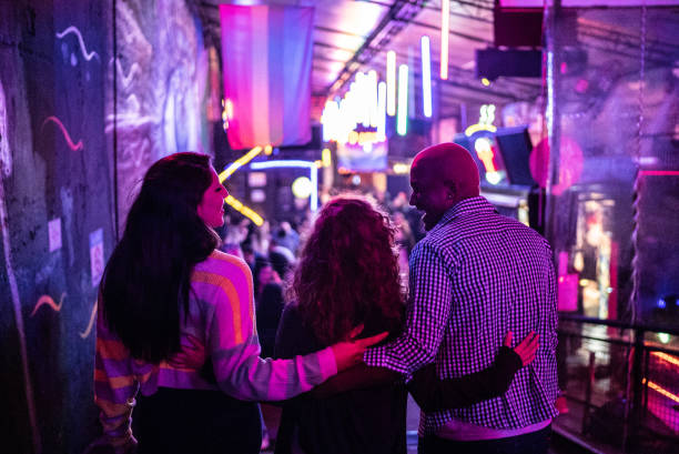 friends embracing at nightlife - including a transgender person - concert stock pictures, royalty-free photos & images