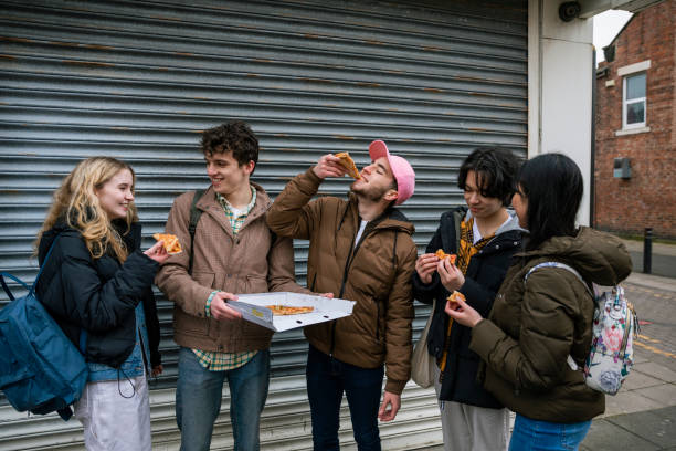 friends enjoying a pizza together - junk food stock pictures, royalty-free photos & images