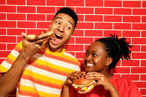 friends enjoying pizza and burgers together - junk food stock pictures, royalty-free photos & images