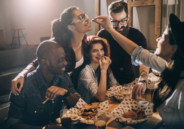 friends enjoying their favorite food place - junk food stock pictures, royalty-free photos & images