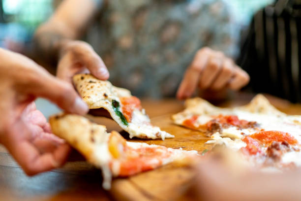 friends getting slices of pizza, using hands - food stock pictures, royalty-free photos & images