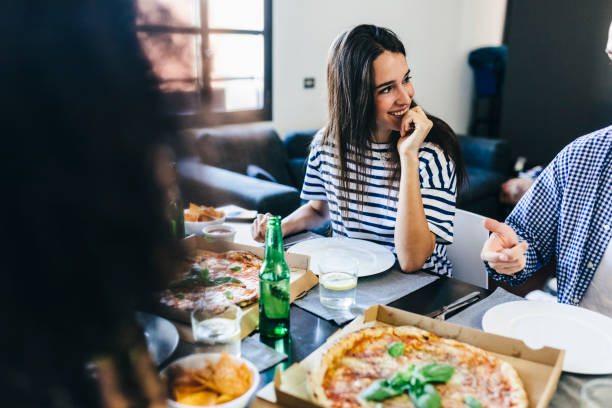 friends having a pizza at home - junk food stock pictures, royalty-free photos & images