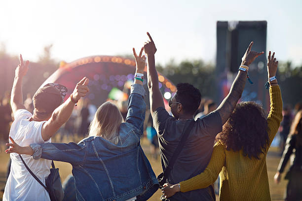 friends having arms in the air in front of stage - concert stock pictures, royalty-free photos & images
