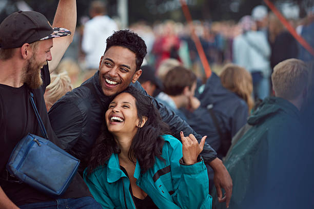 friends laughing together at outside concert - concert stock pictures, royalty-free photos & images
