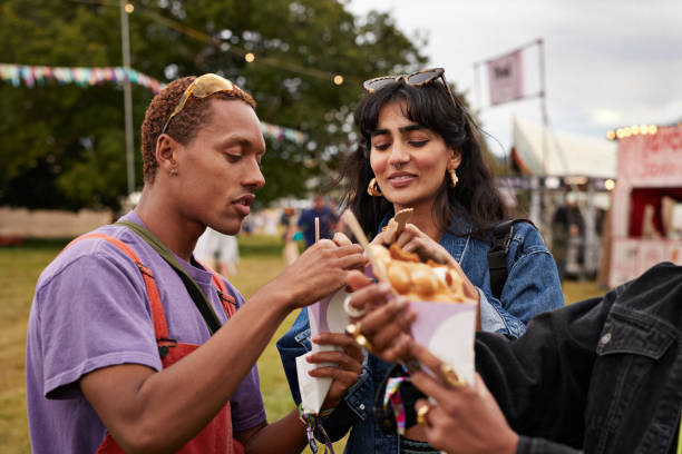 friends sharing dessert at music festival - concert stock pictures, royalty-free photos & images