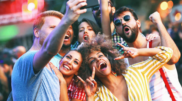 friends snapping selfies. - concert stock pictures, royalty-free photos & images