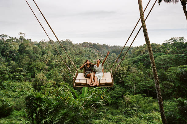 friends swinging together against forest - travel stock pictures, royalty-free photos & images