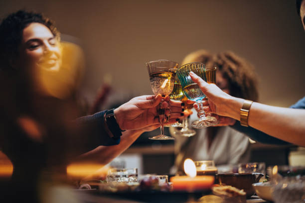 friends toasting with a glass of wine during a dinner celebration - food stockfoto's en -beelden