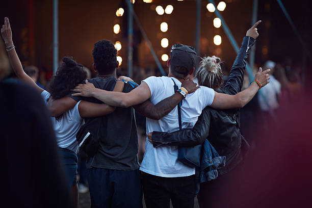 friends with arms around each other at concert - concert stock pictures, royalty-free photos & images