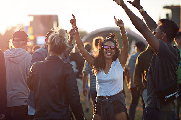 friends with arms in the air at festival concert - concert stock pictures, royalty-free photos & images