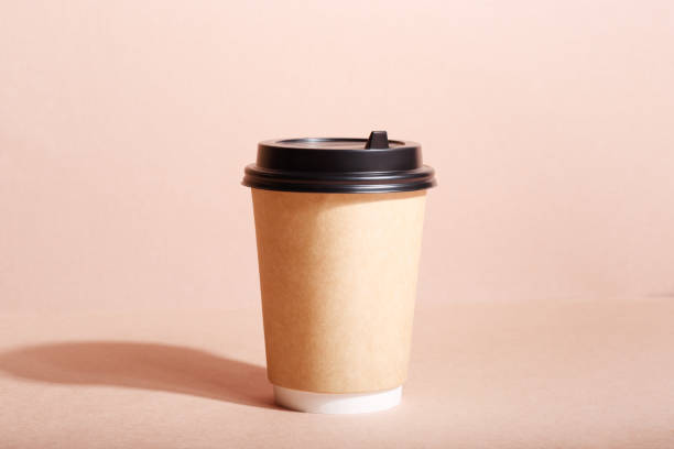 front view of eco friendly paper craft cup for coffee with black lid on the beige background. zero waste, plastic free concept. sustainable lifestyle. front view. - junk food stock pictures, royalty-free photos & images