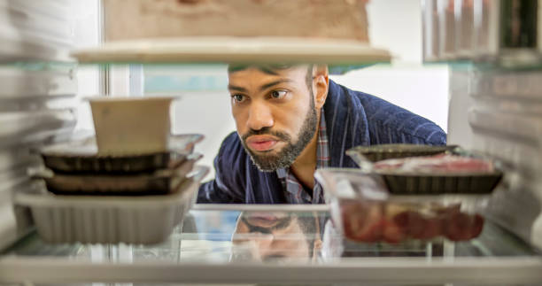frowning man looking food - food stock pictures, royalty-free photos & images