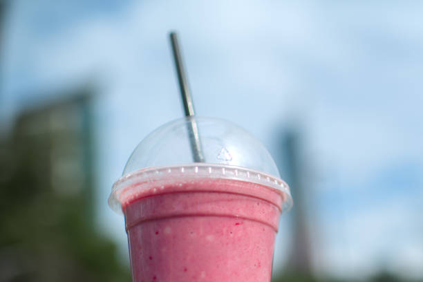 fruit smoothy in plastic take away cup over city background - junk food stock pictures, royalty-free photos & images