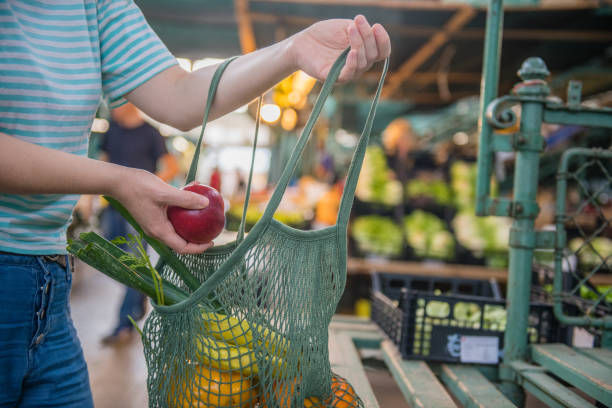 frutas y verduras en una bolsa reutilizable de malla de algodón, zero waste shopping en el mercado al aire libre - food fotografías e imágenes de stock